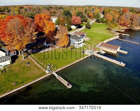 The Aerial View Of The Waterfront Residential Area Surrounded By Striking Fall Foliage By St Lawrenc