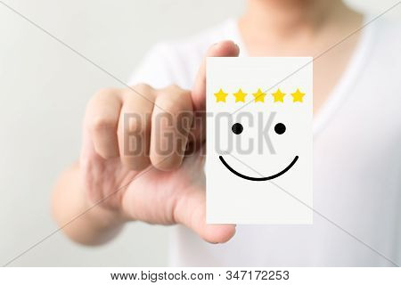 Customer Service Experience And Business Satisfaction Survey. Man Holding Card With Smiley Face With