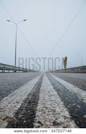 The Dividing Line On The Road Is White The View From Below On The Road Paved Going. Road Markings On