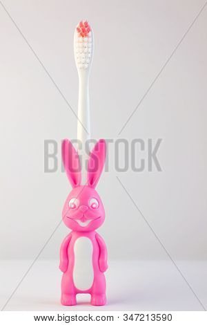 Childrens Toothbrush In A Form Of Cute Pink Bunny On White Background Isolated.rabbit With Smiley Fa