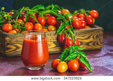 Glass Of Fresh Delicious Jummy Red Tomato Juice And Fresh Tomatoes In Wooden Box. Dark Background. C