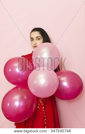 Young Pretty Woman In Red Evening Dress Holding Festive Air Balloons. Portrait Of Happy 20s Middle-e