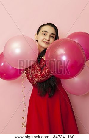 Young Pretty Woman In Red Evening Dress Holding Festive Air Balloons. Portrait Of Happy 20s Middle-e