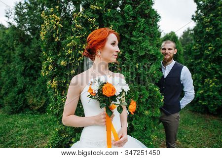 Newly Wed Couple Posing For A Photo In A Juniper Park