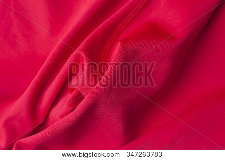 Close-up Fragment Of Crumpled Red Polyester Fabric. Concept Of High-quality Raw Materials For Clothi