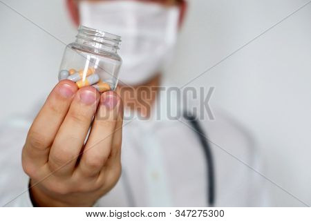 Doctor Giving Pills, Physician In Medical Mask With Bottle Of Capsules. Concept Of Dose Of Drugs, Vi