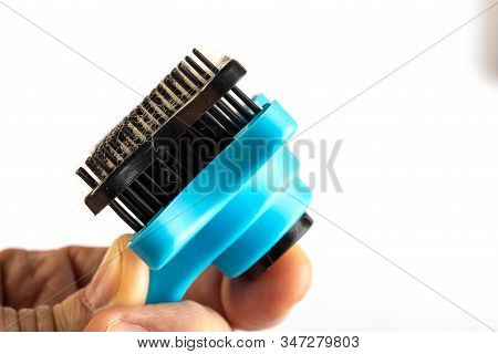 Comb For Combing Cats And Dogs With Button For Cleaning Brush In Man Hand. Studio Photo