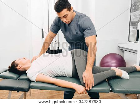 Physical Therapist Twists The Patients Body. Exercises For The Treatment Of The Spine, Treatment Of 