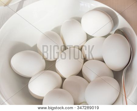 Lots Of White Chicken Eggs In A White Plate On A White Background. The Concept Of Preparation For Ea
