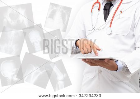 Doctor Holding Tablet Computer With X Ray Film Background