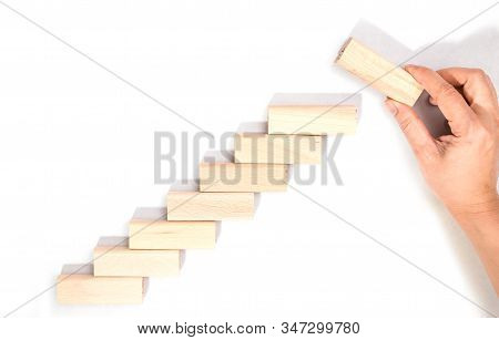 Hand Arranging Wood Block Stacking As Step Stair Isolated On White Background. Business Concept For 