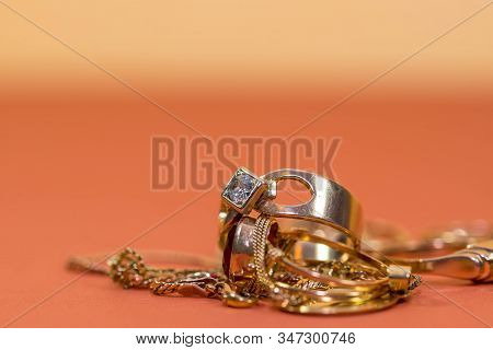 Real Gold Rings With Diamonds, Gems, Neckless On Orange Yellow Background Close Up Macro Shot, Space