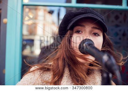 Female Musician Busking Singing Outdoors In Street