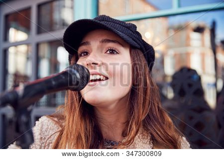 Female Musician Busking Singing Outdoors In Street
