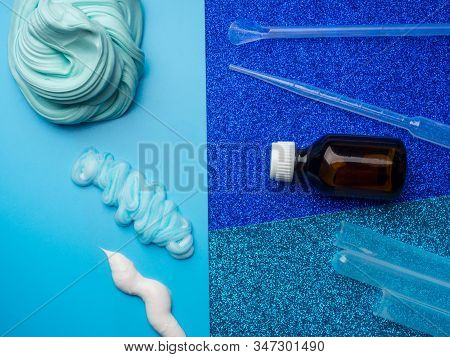 Components To Make Slime. Child Education Concept. On Blue Surface Slime, Toothpaste, Shaving Foam, 