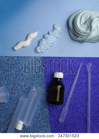 Components To Make Slime. Child Education Concept. On Blue Surface Slime, Toothpaste, Shaving Foam, 