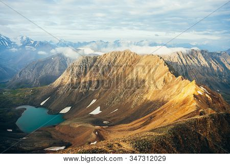 Atmospheric Alpine Landscape To Low Clouds On Big Golden Pointy Rockies In Sunlight. Giant Mountains