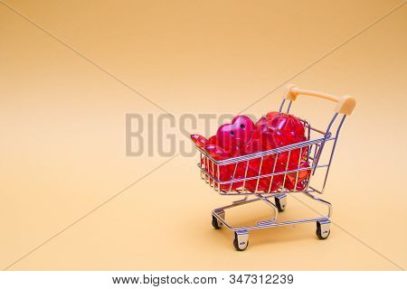Shopping Troley With A Lot Of Red Hearts On A Yellow Background Copy Space 14 February Concept