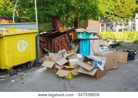 A Lot Of Empty Cardboard Boxes, Old Wooden Furniture And Trash Container In Backyard: Ufa, Russia - 