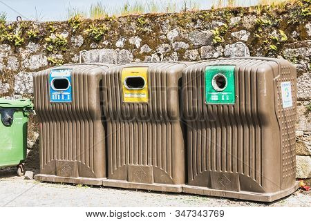 Public Recycling Bins In Front Of A Stone Wall In Vila Cha, Portugal