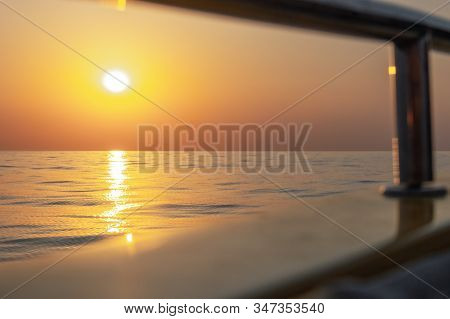 Bright Sunset With Large Yellow Sun Under The Sea Surface. Beautiful Sunset Over The Sea.