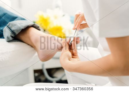 Podiatrist working on men's feet in her parlor