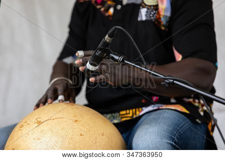 Midsection Of African Male Professional Musician Playing Calabash On Stage During Event In City At W