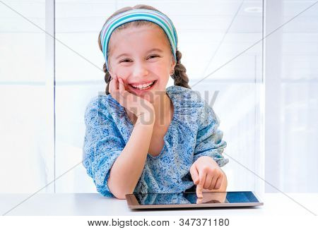 Happy little girl and her magic tablet