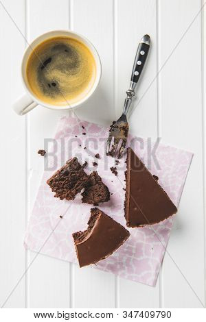 Chocolate brownies cake on paper napkin and coffee cup.