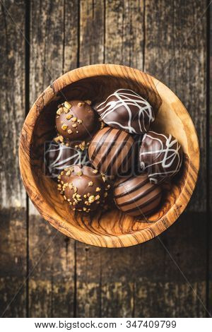 Praline bonbons. Chocolate truffles in wooden bowl. Top view.