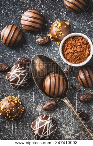 Praline bonbons. Chocolate truffles and cocoa powder on old kitchen table.