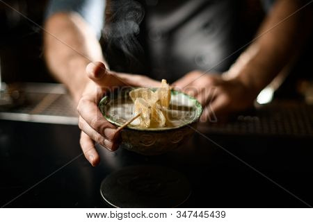 Bartender Holding A Deep Plate With The Toothpick With The Dried Sugar Pinepple Slices