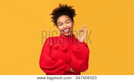 Im Fine. Happy Afro Woman Showing Approval Gesture And Smiling Isolated Over Orange Studio Wall, Cop