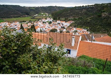 Overlook From A Hill, Looking Over The Rooftops Of Houses And Buildings Of Odeceixe, Portugal, A Tow