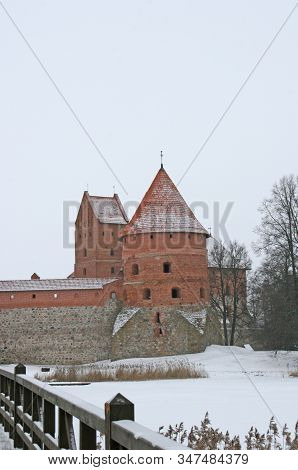 Gothic Red Brick Trakai Castle In Winter Time, In The Middle Of Frozen Lake, Lithuania