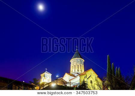 Georgia, Tbilisi All Saints Church At Sunset On A Winter Evening. Dark Blue Sky, Moon, Dome Of The T