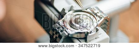 Panoramic Shot Of Wristwatch On Watch Tester By Tweezers On Table