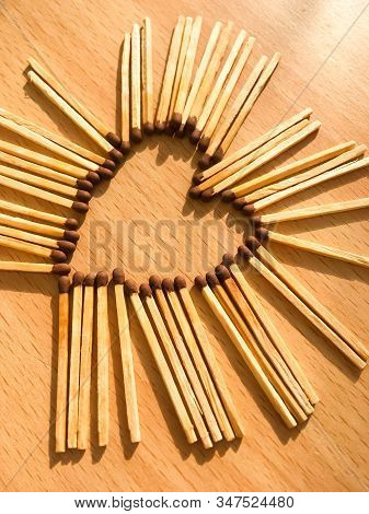 Wooden Safety Matches On A Wooden Background Arranged In The Shape Of A Heart. Matchsticks In The Sh