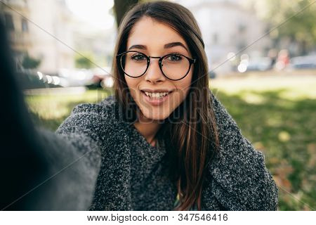 Beautiful Young Woman Taking Self Portrait On Smart Phone. Female Wears Knitted Sweater, Transparent