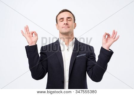 Man In Suit And White Shirt Standing, Raised Arms, Closed Eyes With Yoga Gesture And Meditation