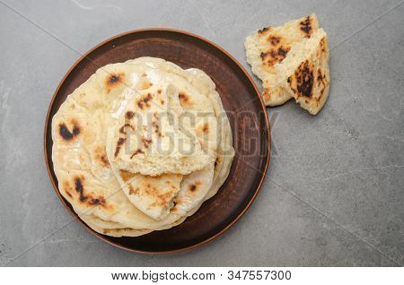 Flat Lay View At Homemade Tasty Traditional Pita Bread Stacked In Clay Dish On Stone Kitchen Table