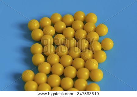 Yellow Vitamins On A Blue Background. Vitamin Complex Against The Virus. Multivitamins To Enhance He