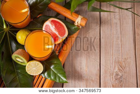 Glasses Of Tropical Exotic Multifruit Juice On A Palm Leaves. Top View. Copy Space