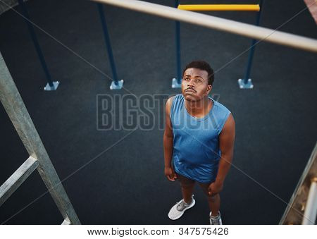 High Angle View Of A Sporty Young Man Preparing To Do Pull Ups On A Bar At The Outdoor Gym In The Pa