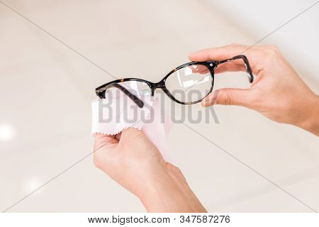 Vision Problems. Closeup Hands Of A Woman Wiping Her Glasses