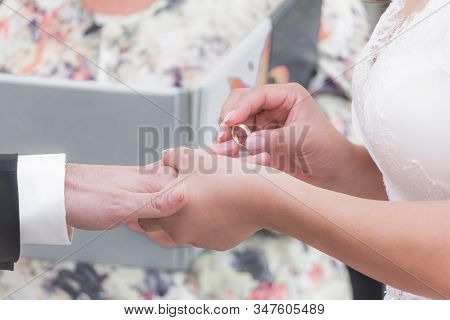 Wedding Bride And Groom Couple At Marriage Ring Vows Ceremony. Husband With Dark Suit And Wife With 