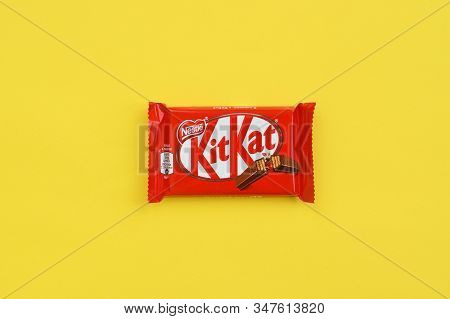 Kit Kat Chocolate Bar In Red Wrapping Lies On Yellow Background. Kit Kat Created By Rowntrees Of Yor