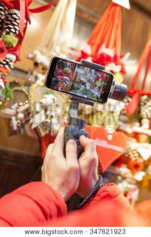 Germany, Munich - December 20, 2018: Close-up Of Man Blogger Hands Shooting Video On Smartphone Ipho