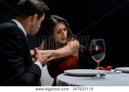 Selective Focus Of Couple Quarreling By Wine Glass On Served Table Isolated On Black