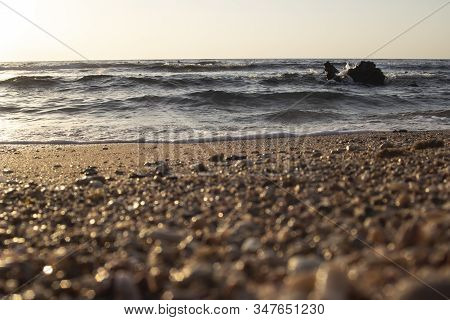 A Pair Of Beach Red And Black Slippers On The Golden Sand